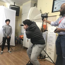 Erik James Montgomery works with students at Bradley Beach Elementary to set up a mobile photography studio.